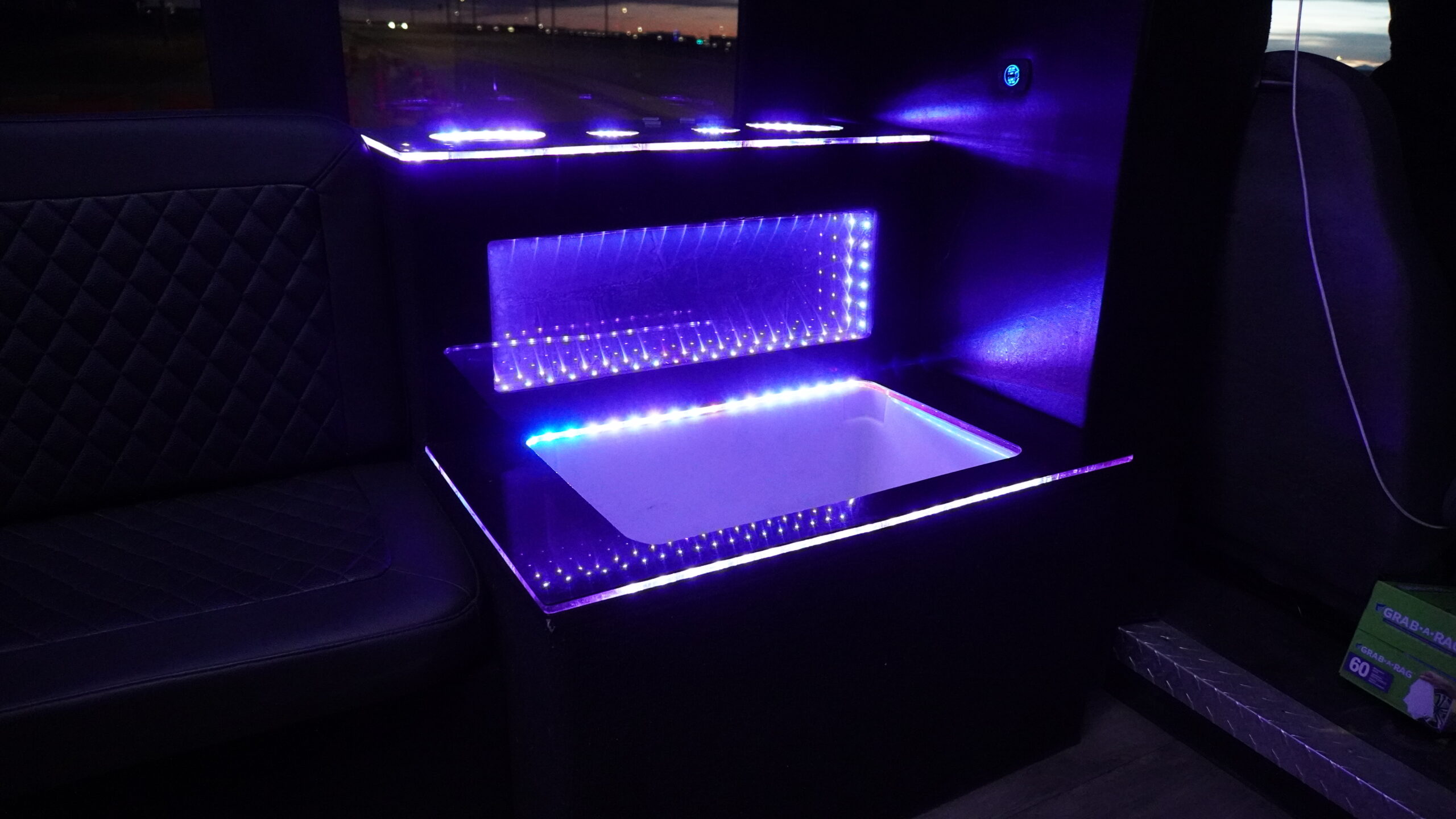 Crafting Captivating Headlines: Your awesome post title goes here Luxury interior of a Calgary party bus with LED lighting and premium seating. With a Cooler for drinks